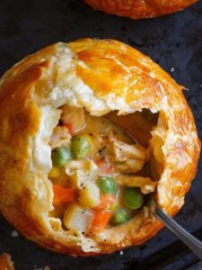 A savory chicken pot pie nestled in a pot, featuring a flaky crust and rich filling, inspired by Taste of Home Recipes.