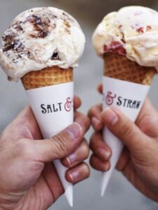  Two friends delight in ice cream cones featuring "Salt" and "Straw," highlighting the best ice cream flavors.