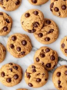  A cluster of freshly baked chocolate chip cookies arranged on a polished marble surface, showcasing their deliciousness.