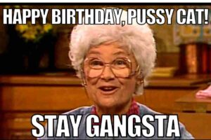 An old lady with glasses smiles while holding a birthday card that says, "Happy Birthday, Pussey Cat, Stay Gangsta."