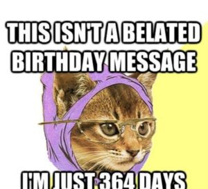 A cat in glasses and a purple shirt humorously declares, "This isn't a belated birthday message, I'm just 34 days late."