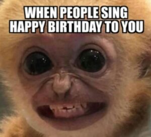 A cheerful monkey grinning widely, captioned with "when people sing happy birthday to you," embodying birthday joy.